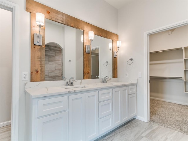 14613 Brantwood Cir, Oklahoma City, OK 73142 - bathroom featuring double vanity, a walk in closet, and baseboards