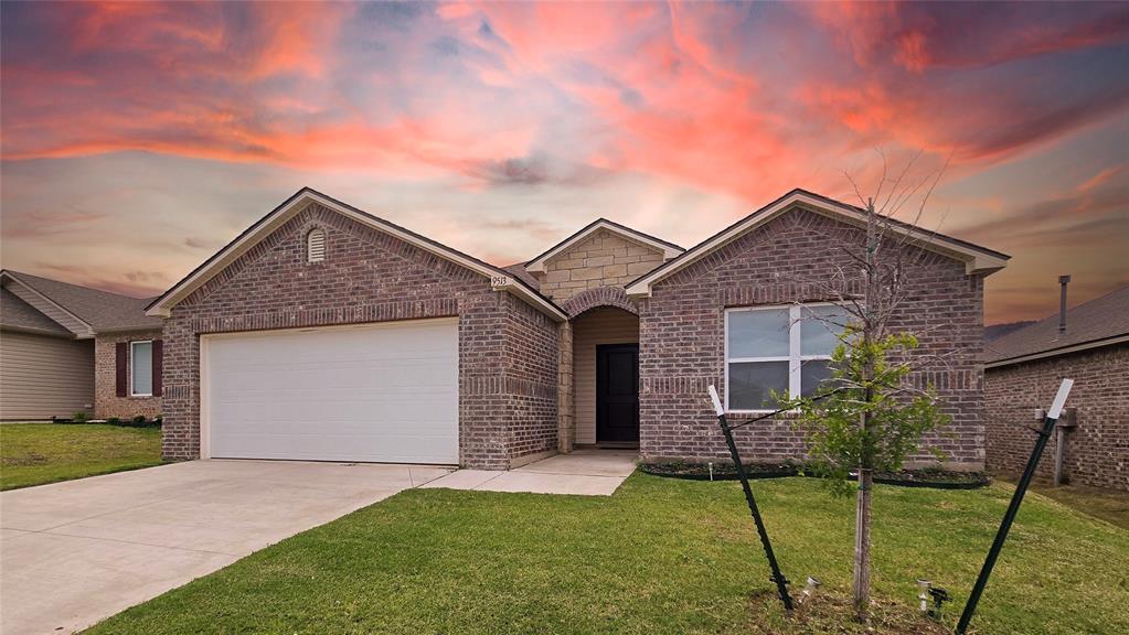 9513 Laredo Ln, Yukon, OK 73099 - view of front of property with brick siding, an attached garage, a front yard, and concrete driveway