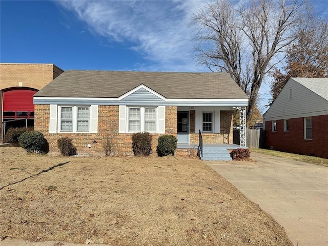 3117 NW 23rd St, Oklahoma City, OK 73107 - view of front of home with covered porch, brick siding, and roof with shingles