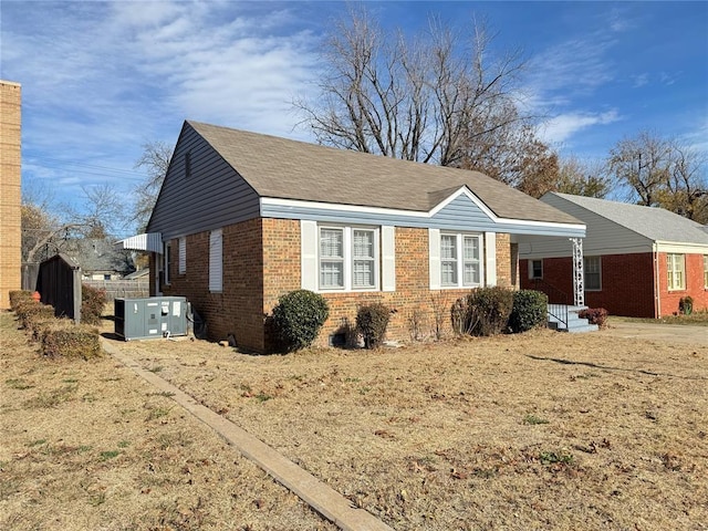 3117 NW 23rd St, Oklahoma City, OK 73107 - view of front of home with brick siding, central AC unit, and covered porch