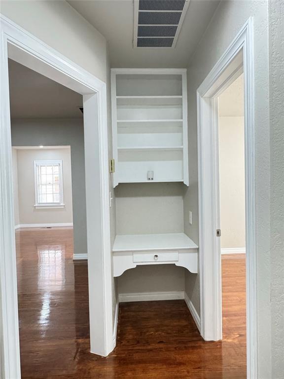 3117 NW 23rd St, Oklahoma City, OK 73107 - hall with an office area, dark wood-type flooring, baseboards, and built in shelves