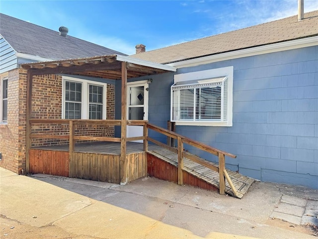 3117 NW 23rd St, Oklahoma City, OK 73107 - property entrance with a chimney, a shingled roof, and brick siding
