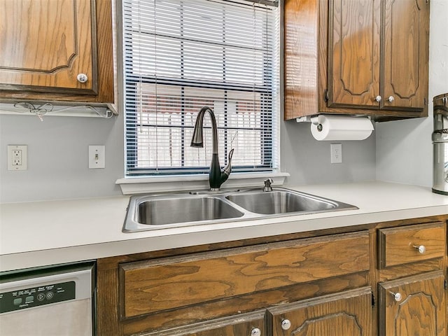 16716 Valley Crst, Edmond, OK 73012 - kitchen featuring dishwasher, a sink, brown cabinetry, and light countertops