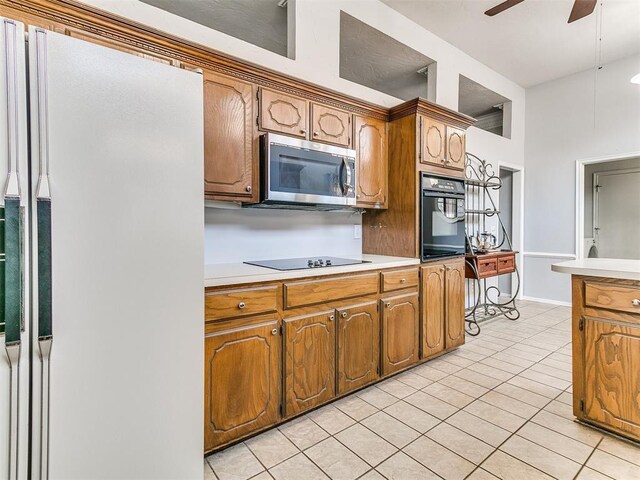16716 Valley Crst, Edmond, OK 73012 - kitchen featuring black appliances, ceiling fan, light tile patterned floors, and light countertops