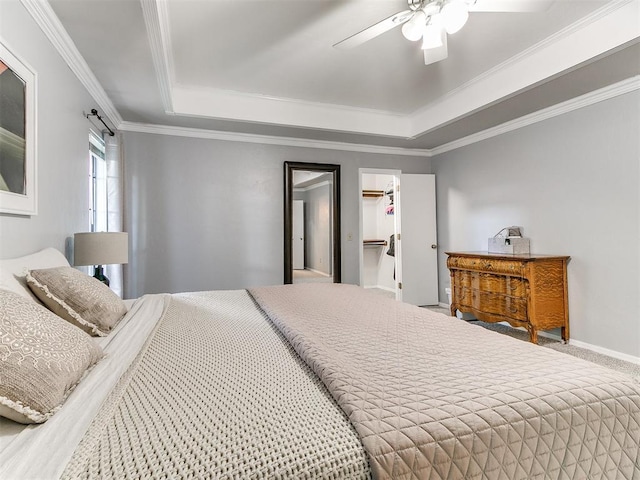 16716 Valley Crst, Edmond, OK 73012 - carpeted bedroom with a tray ceiling, crown molding, ceiling fan, a spacious closet, and baseboards