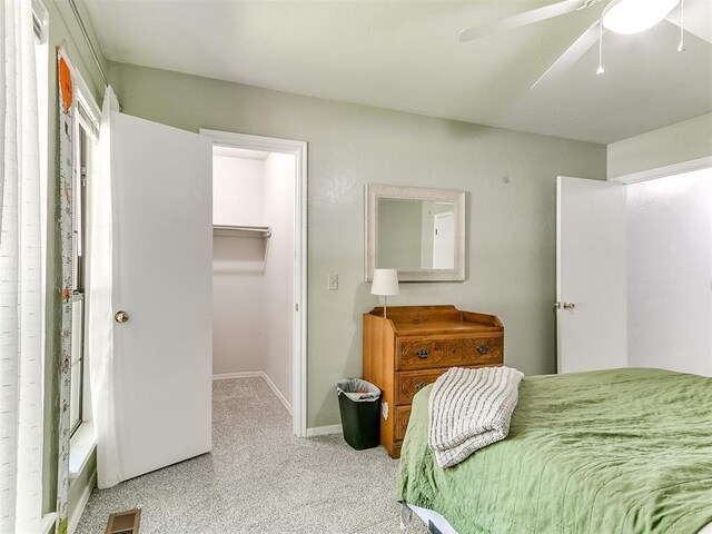 16716 Valley Crst, Edmond, OK 73012 - carpeted bedroom featuring a walk in closet, baseboards, a ceiling fan, and a closet