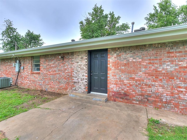 2713 SW 75th St, Oklahoma City, OK 73159 - entrance to property with cooling unit, brick siding, and a patio area