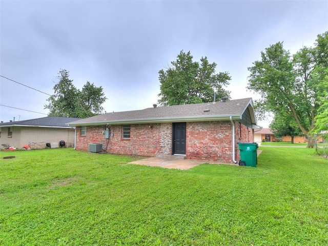 2713 SW 75th St, Oklahoma City, OK 73159 - back of property with brick siding, a patio, a yard, and central AC unit