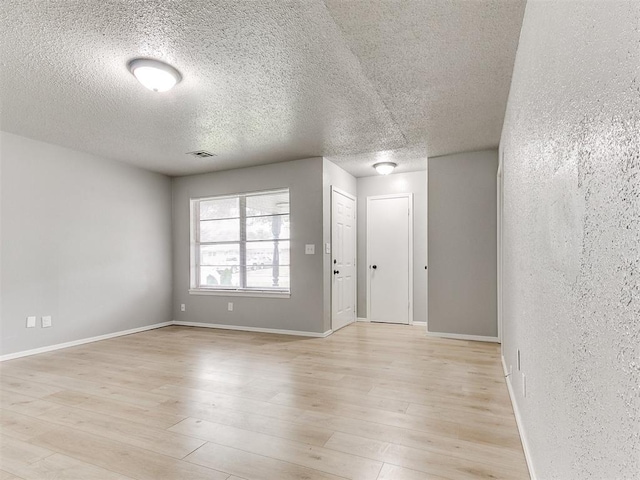 2713 SW 75th St, Oklahoma City, OK 73159 - empty room featuring a textured ceiling, light wood-style flooring, and baseboards