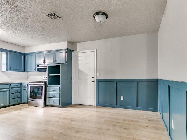 2713 SW 75th St, Oklahoma City, OK 73159 - kitchen featuring electric range, a textured ceiling, light wood finished floors, a wainscoted wall, and a decorative wall