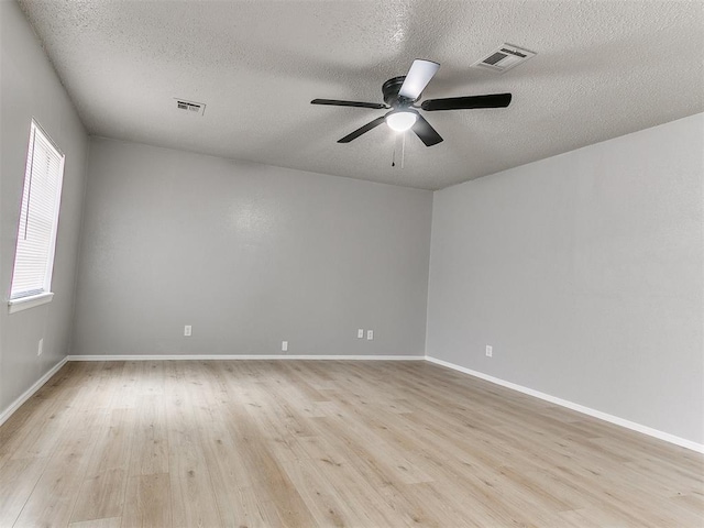 2713 SW 75th St, Oklahoma City, OK 73159 - unfurnished room with a textured ceiling, a ceiling fan, light wood finished floors, and baseboards