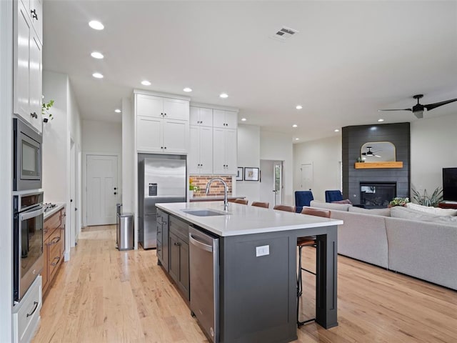 4304 NW 154th Pl, Edmond, OK 73013 - kitchen featuring appliances with stainless steel finishes, white cabinetry, light wood-style floors, and recessed lighting