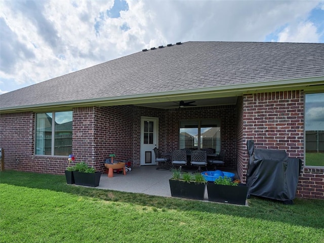 4304 NW 154th Pl, Edmond, OK 73013 - rear view of property featuring ceiling fan, a shingled roof, brick siding, a lawn, and a patio