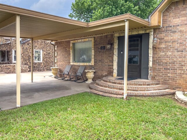 1117 SW 37th St, Oklahoma City, OK 73109 - doorway to property with brick siding, a patio, and a lawn