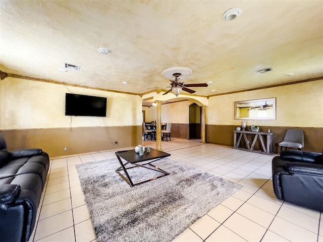 1117 SW 37th St, Oklahoma City, OK 73109 - living room with arched walkways, a wainscoted wall, ornamental molding, tile patterned floors, and a ceiling fan