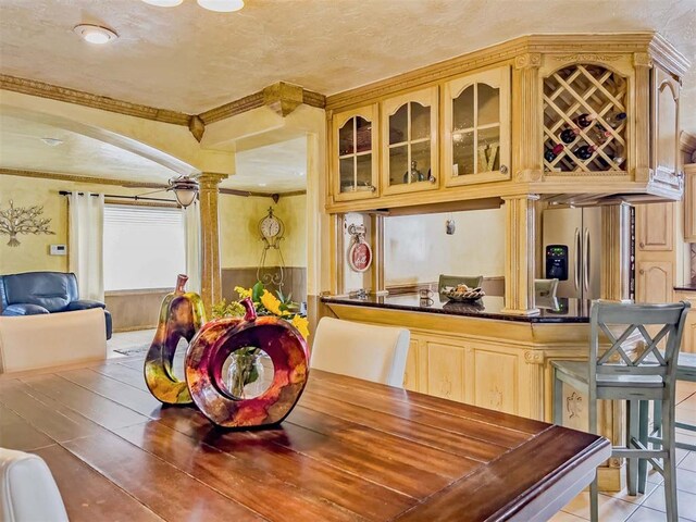 1117 SW 37th St, Oklahoma City, OK 73109 - dining space featuring ornate columns, ornamental molding, arched walkways, and light tile patterned floors