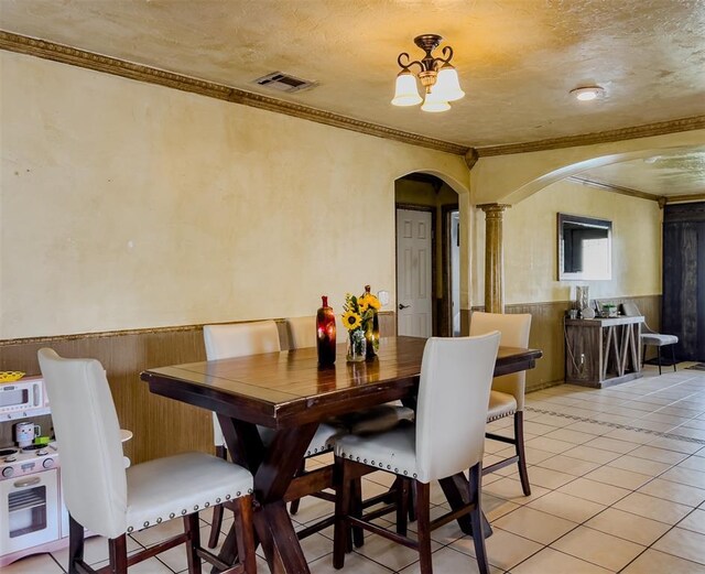 1117 SW 37th St, Oklahoma City, OK 73109 - dining room with arched walkways, crown molding, ornate columns, a wainscoted wall, and light tile patterned floors