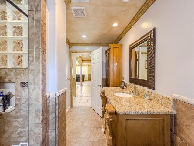 1117 SW 37th St, Oklahoma City, OK 73109 - bathroom featuring ornamental molding, vanity, tile patterned floors, and tiled shower