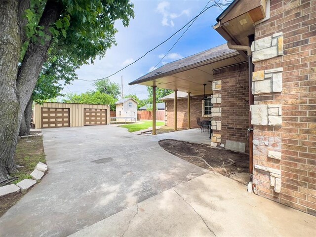 1117 SW 37th St, Oklahoma City, OK 73109 - view of patio / terrace with a detached garage and an outbuilding