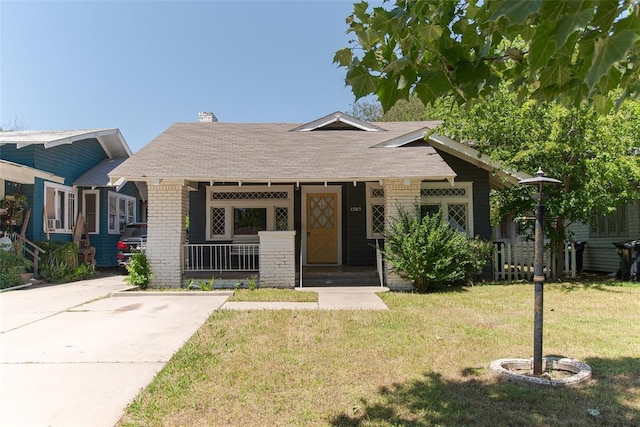 1505 NW 34th St, Oklahoma City, OK 73118 - view of front of home with covered porch, a front yard, roof with shingles, brick siding, and a chimney