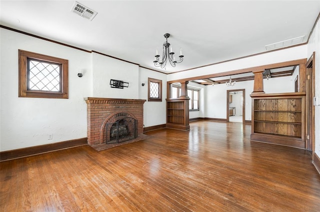 1505 NW 34th St, Oklahoma City, OK 73118 - unfurnished living room with a chandelier, baseboards, wood-type flooring, crown molding, and a brick fireplace