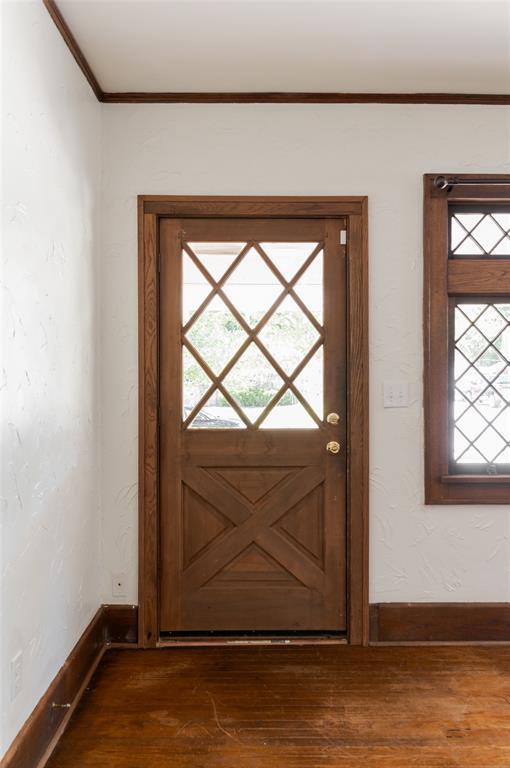 1505 NW 34th St, Oklahoma City, OK 73118 - doorway to outside with healthy amount of natural light, dark wood-style floors, crown molding, and baseboards