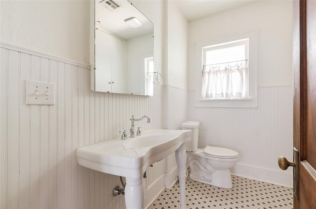 1505 NW 34th St, Oklahoma City, OK 73118 - bathroom featuring a wainscoted wall, toilet, and tile patterned flooring