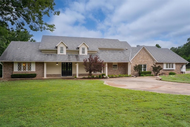 2108 Woodhill Rd, Edmond, OK 73025 - view of front of house with a front yard, brick siding, and driveway