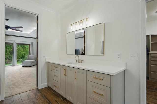 2108 Woodhill Rd, Edmond, OK 73025 - bathroom with a ceiling fan, wood finished floors, vanity, ornamental molding, and baseboards