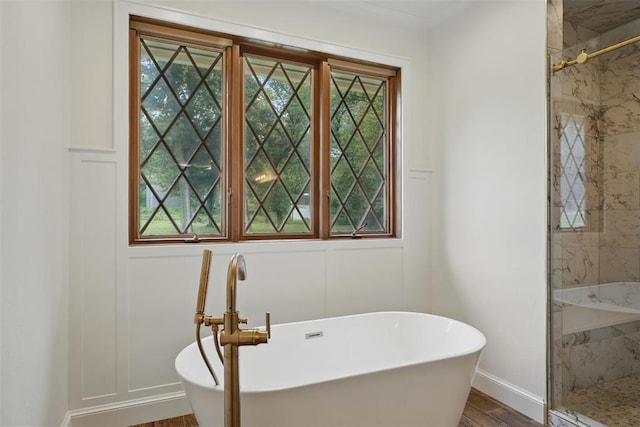 2108 Woodhill Rd, Edmond, OK 73025 - full bathroom featuring a stall shower, a freestanding tub, baseboards, and wood finished floors