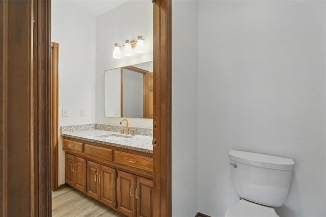 2108 Woodhill Rd, Edmond, OK 73025 - bathroom with vanity, toilet, and wood finished floors