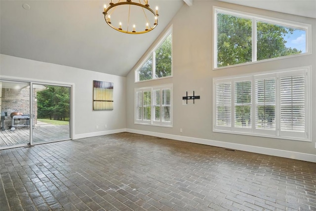 2108 Woodhill Rd, Edmond, OK 73025 - unfurnished living room with high vaulted ceiling, brick flooring, a chandelier, and healthy amount of natural light
