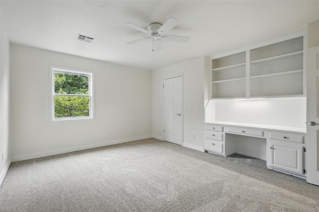 2108 Woodhill Rd, Edmond, OK 73025 - unfurnished office with light colored carpet, a ceiling fan, built in desk, and baseboards