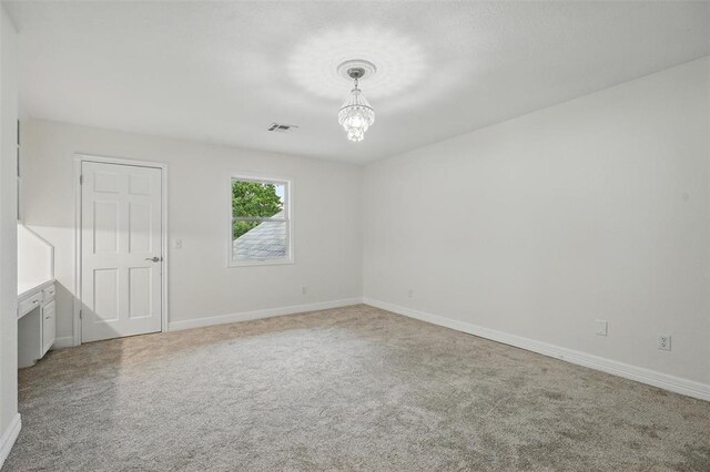 2108 Woodhill Rd, Edmond, OK 73025 - carpeted empty room featuring a chandelier and baseboards