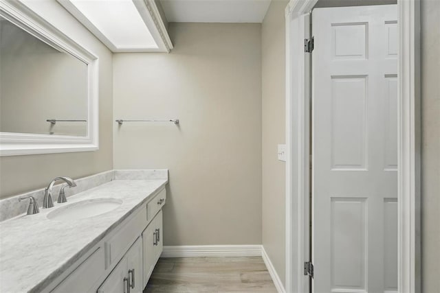 2108 Woodhill Rd, Edmond, OK 73025 - bathroom featuring vanity, baseboards, and wood finished floors