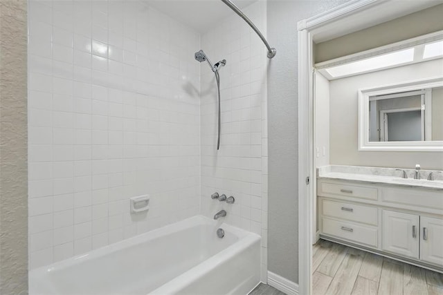 2108 Woodhill Rd, Edmond, OK 73025 - full bath with bathtub / shower combination, vanity, a textured wall, baseboards, and wood finished floors