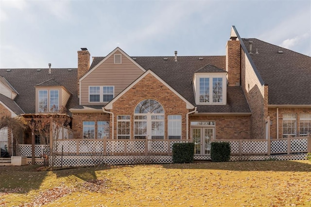 607 Aberdeen Rd, Edmond, OK 73025 - back of house with french doors, brick siding, roof with shingles, and a chimney