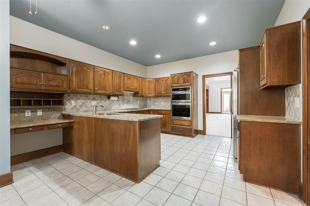 607 Aberdeen Rd, Edmond, OK 73025 - kitchen with open shelves, a peninsula, stainless steel appliances, backsplash, and brown cabinets
