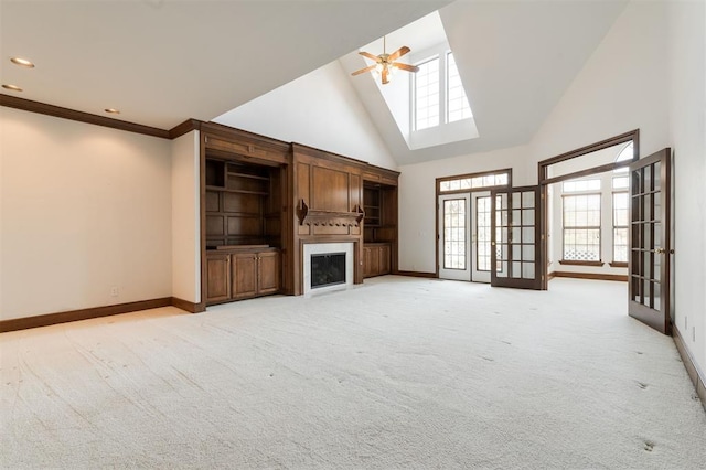 607 Aberdeen Rd, Edmond, OK 73025 - unfurnished living room with baseboards, high vaulted ceiling, a ceiling fan, a fireplace, and light colored carpet