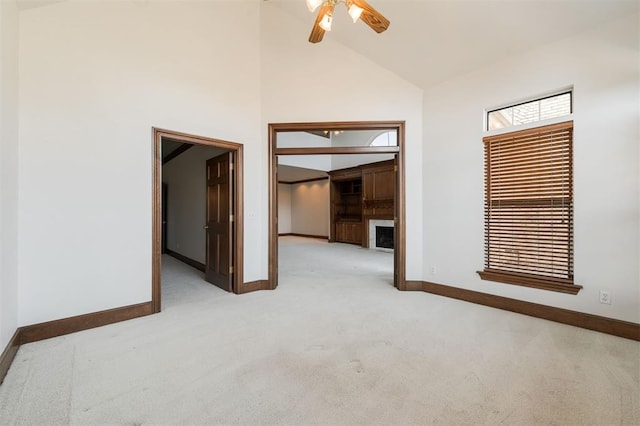 607 Aberdeen Rd, Edmond, OK 73025 - carpeted spare room featuring baseboards, high vaulted ceiling, ceiling fan, and a fireplace