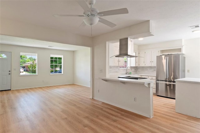 1121 NW 105th St, Oklahoma City, OK 73114 - kitchen with freestanding refrigerator, island exhaust hood, a peninsula, light countertops, and recessed lighting