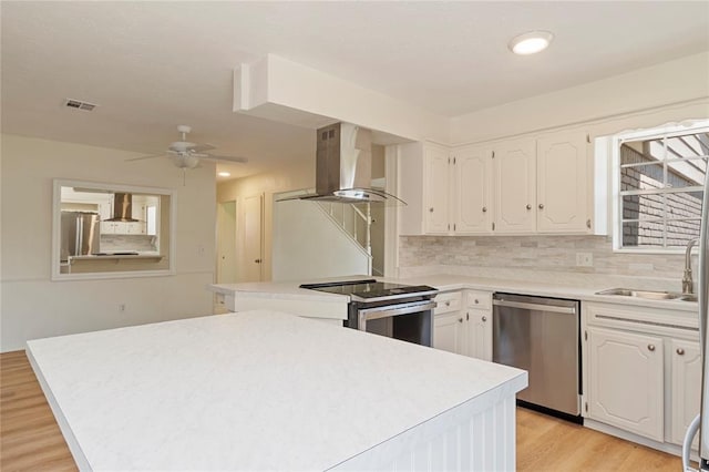 1121 NW 105th St, Oklahoma City, OK 73114 - kitchen with appliances with stainless steel finishes, wall chimney range hood, white cabinetry, and recessed lighting