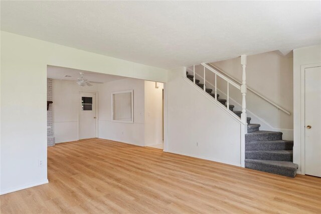 1121 NW 105th St, Oklahoma City, OK 73114 - unfurnished living room featuring wood finished floors, stairway, and a ceiling fan