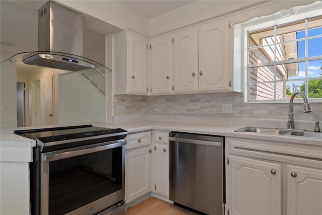 1121 NW 105th St, Oklahoma City, OK 73114 - kitchen with island range hood, stainless steel appliances, white cabinetry, and decorative backsplash
