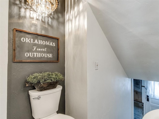 1218 NW 21st St, Oklahoma City, OK 73106 - half bathroom featuring toilet, a chandelier, and vaulted ceiling