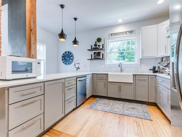 1218 NW 21st St, Oklahoma City, OK 73106 - kitchen featuring appliances with stainless steel finishes, gray cabinets, a sink, tasteful backsplash, and light wood-style flooring