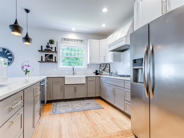 1218 NW 21st St, Oklahoma City, OK 73106 - kitchen with stainless steel appliances, a sink, gray cabinets, light wood-style flooring, and open shelves