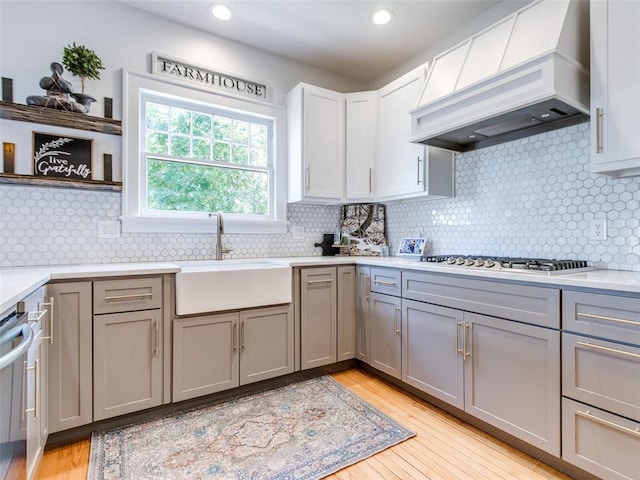 1218 NW 21st St, Oklahoma City, OK 73106 - kitchen with a sink, custom exhaust hood, gray cabinetry, light wood-type flooring, and light countertops