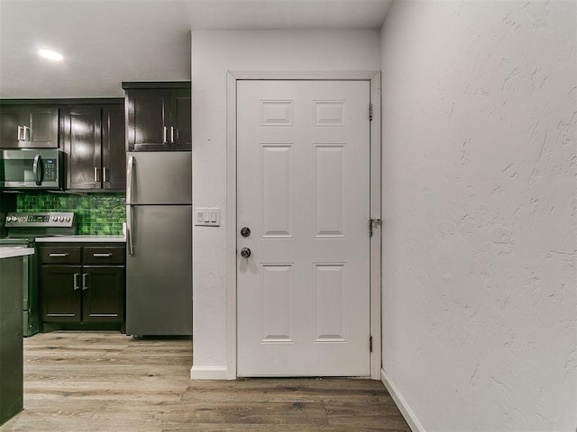 931 NW 7th St Unit 104, Oklahoma City, OK 73106 - kitchen featuring stainless steel appliances, tasteful backsplash, light wood finished floors, light countertops, and green cabinets
