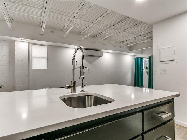 931 NW 7th St Unit 104, Oklahoma City, OK 73106 - kitchen with light countertops, a wall unit AC, and light wood-type flooring